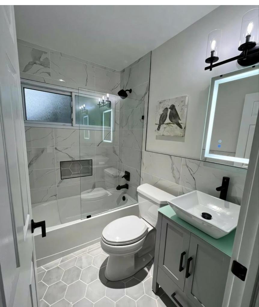 Contemporary bathroom featuring hexagon floor tile, built-in niche and LED mirror