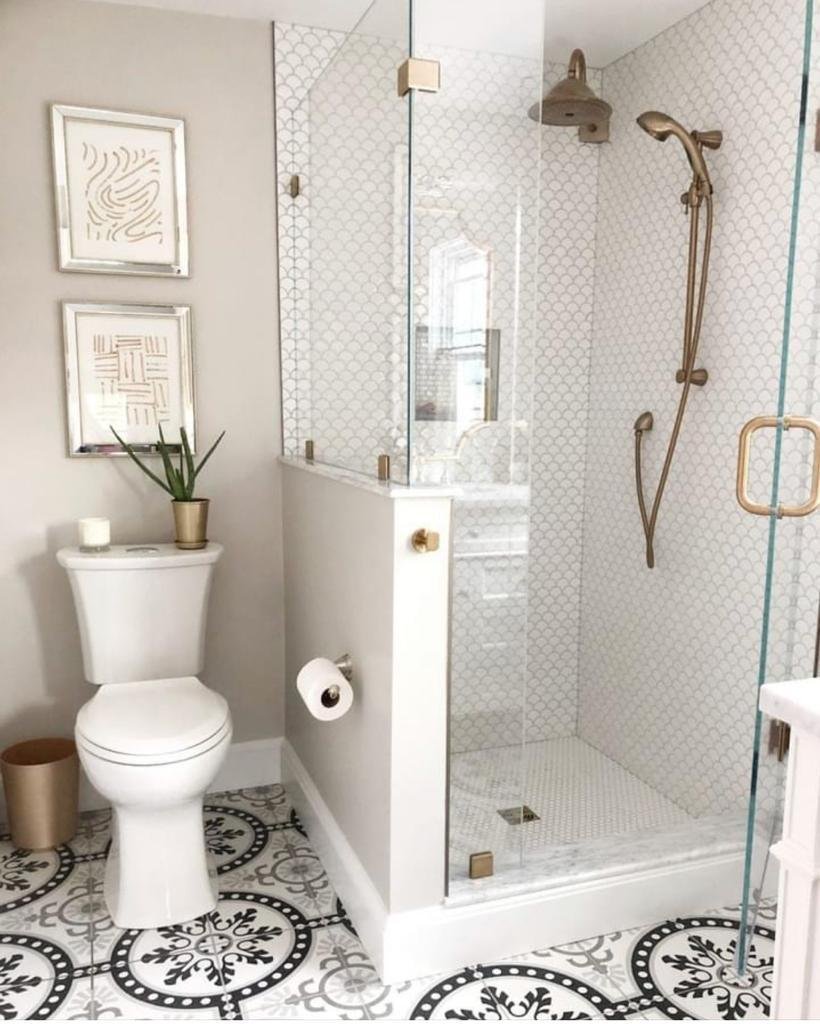 Classic luxury bathroom with brushed gold shower fixtures and scallop tiles