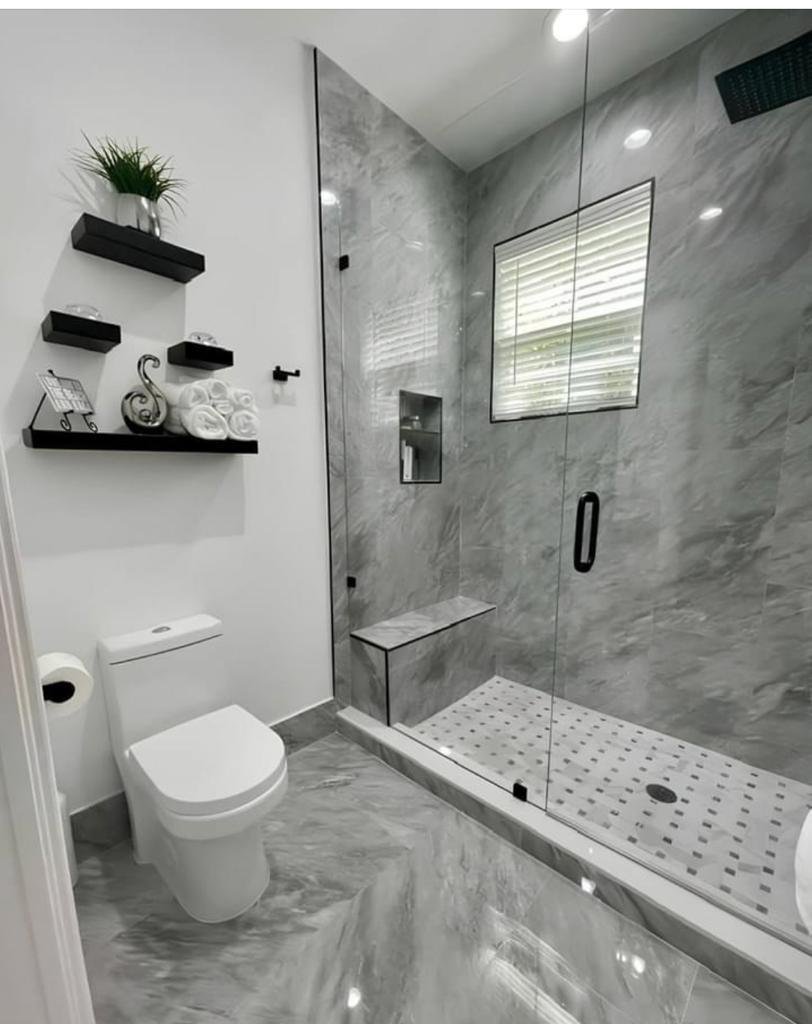 Spa-inspired bathroom featuring gray marble walls and built-in shower bench